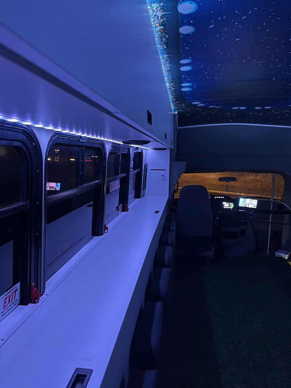 Mitzvah Tank 4 tailgating bus interior at night, featuring vibrant LED lighting and stadium murals for an electrifying atmosphere.