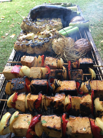 Grilled tofu skewers and other vegetables outdoors on a barbecue grill. Delicious food