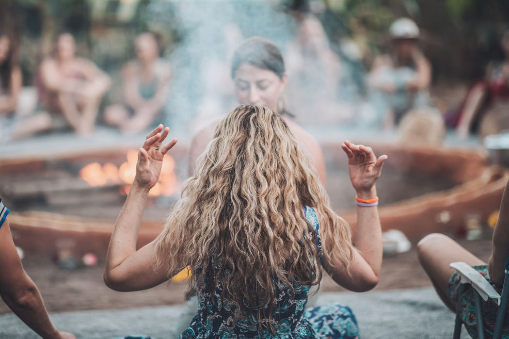 A woman purifies another woman with incense.