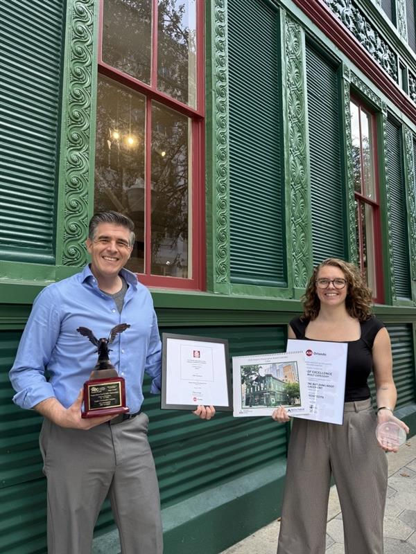 Man and woman holding a plaque