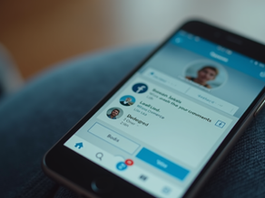 Une bague de fiançailles posée entre deux smartphones affichant des notifications, une bougie allumée et un carnet au texte inspirant.