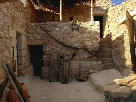 Pesebre artesanal que recrea una casa de piedra en Nazaret, con escaleras, utensilios y detalles rústicos para un nacimiento navideño auténtico.
