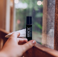 Woman's hand reaching for lavender vanilla perfume oil