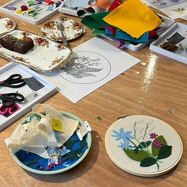 a table is set with materials for an embroidery workshop