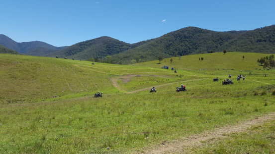 Rolling green hills with some riders practicing skills