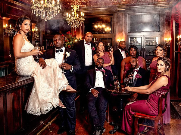 A bride sitting on a bar with groomsmen on either side of her