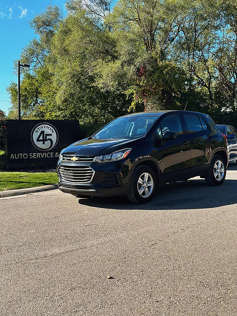 Black Chevrolet Trax parked at Station 45 Auto Repair & Auto Sales signage