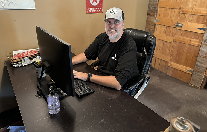 Smiling team member working at a desk with a computer.