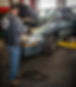 Mechanic using diagnostic tool on car engine in shop