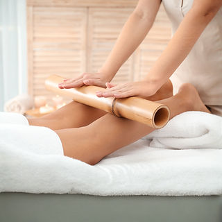 Therapist performing a bamboo leg massage.