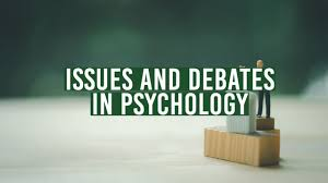 Small figure speaks at a podium on wooden blocks against a blurred green background. Text reads "Issues and Debates in Psychology."
