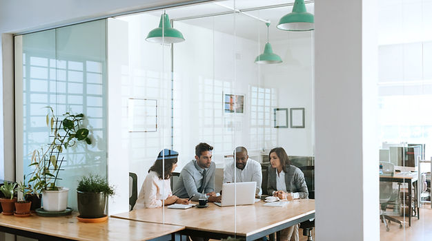 professionals sitting in boardroom with a laptop computer