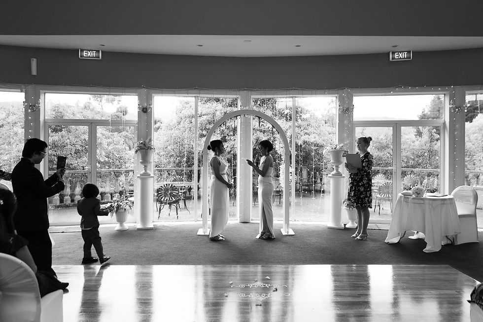 A magical indoor wedding at Aston Norwood, Kaitoke, as raindrops dance on the windows. The warm glow of lights illuminates the ceremony, creating an intimate and enchanting atmosphere.