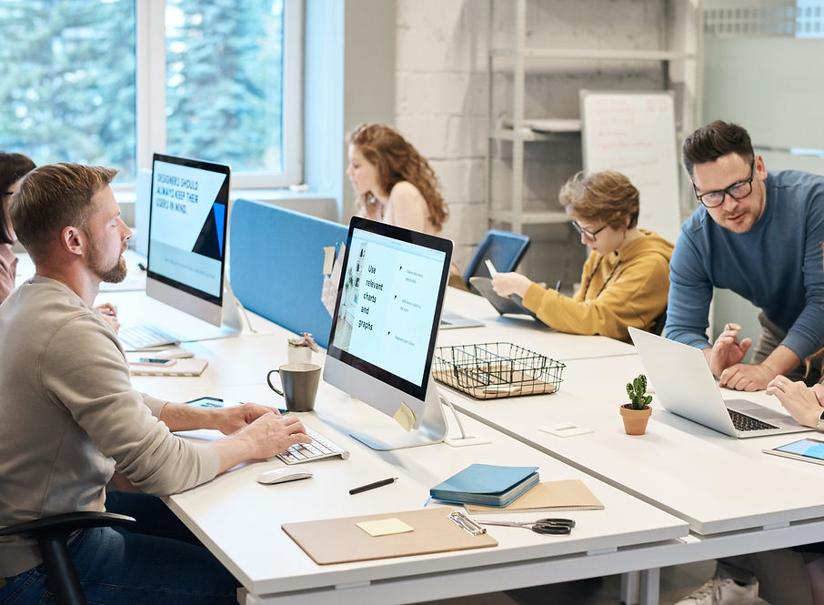 Staff at a business all working around a table using apple computers