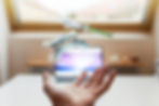 Hand under floating dental aligners and syringe over a desk. Blurred laptop in background. Bright, minimalistic space.