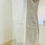 Thumbnail: Side view of a light beige linen dress with short sleeves, subtle herringbone texture, and an abstract printed hem