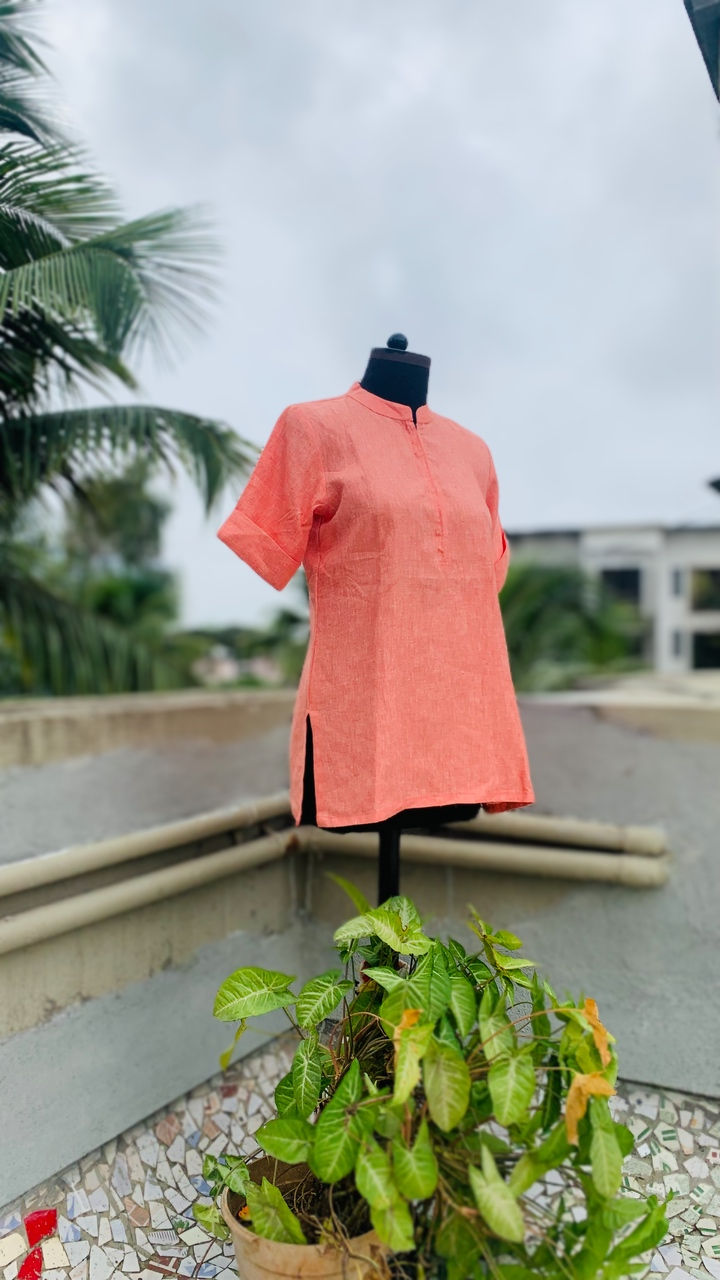 Azitiz linen kurta tunic on model, set against a backdrop of lush green leaves, emphasizing simplicity and comfort