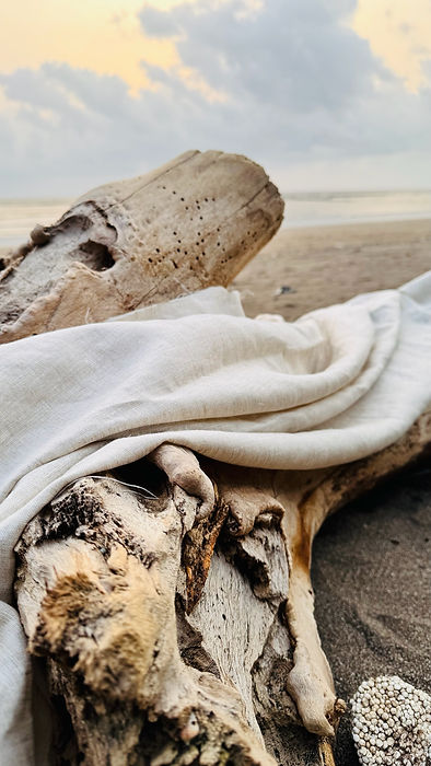 White linen fabric on driftwood at the beach, www.azitiz.in, Pure Linen Clothing Brand.