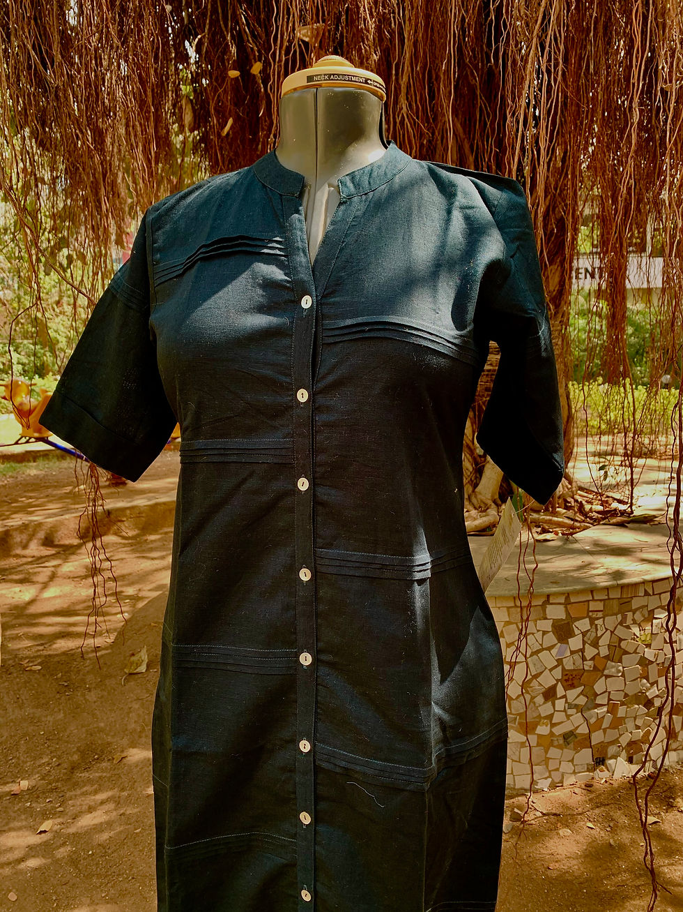 Navy blue button-front dress with half sleeves and pleated panel detailing, displayed on a mannequin in a garden.