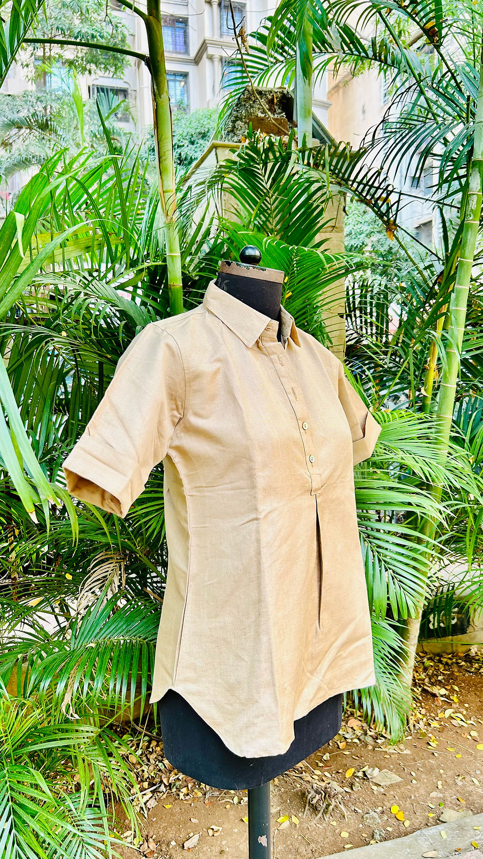 Model wearing Azitiz collared casual cotton top, standing in natural outdoor setting with trees