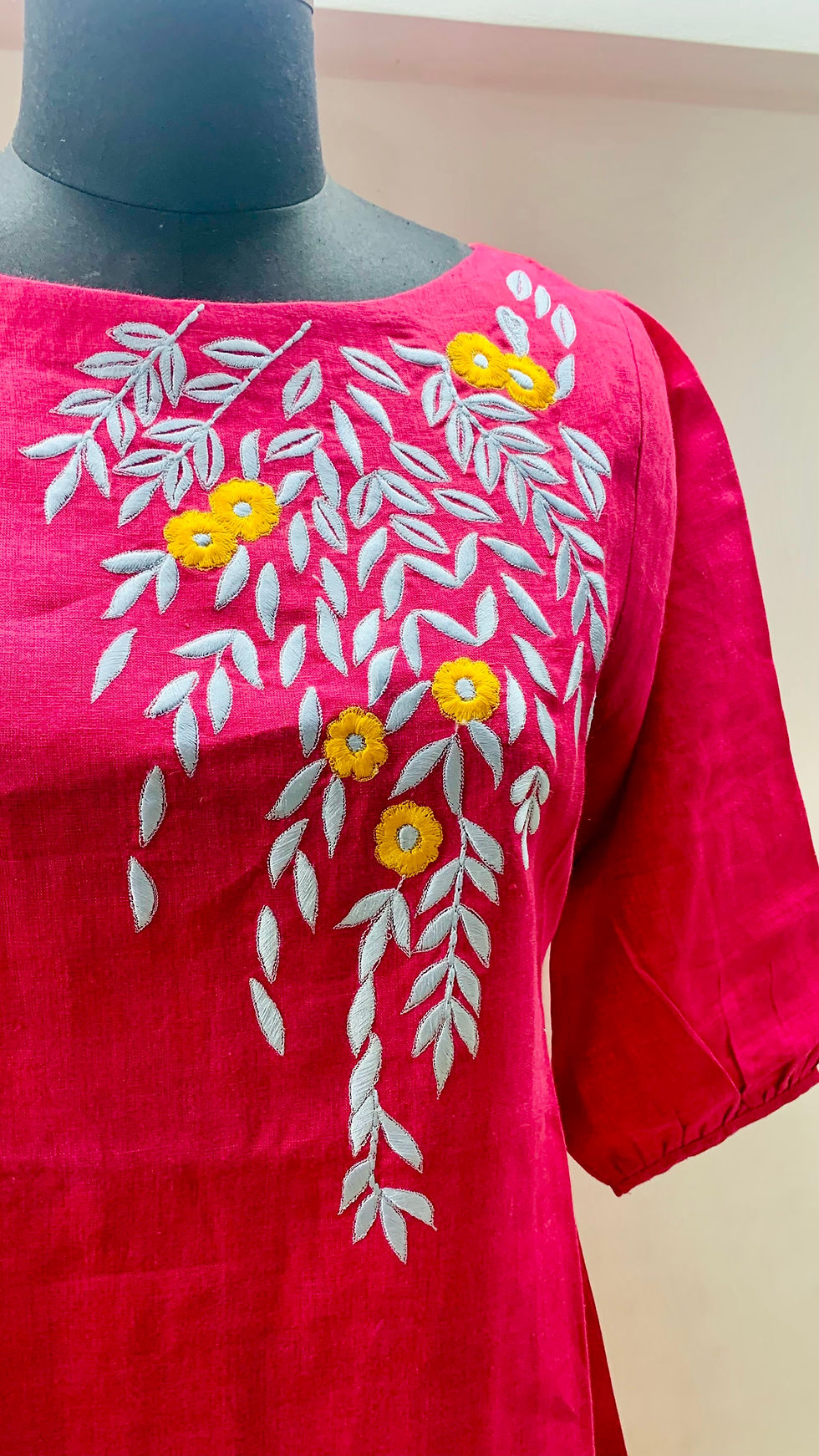 Model wearing a deep pink embroidered linen dress by Azitiz, showcasing the A-line fit
