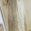 Thumbnail: Side slanted view of the maxi dress with overlapping high v neck and straight elbow length sleeves and a mirror next to it