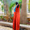 Thumbnail: Side view of Azitiz red linen maxi dress captured mid-motion, surrounded by greenery