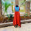 Thumbnail: Azitiz red linen maxi dress flowing gracefully in an open outdoor space surrounded by greenery