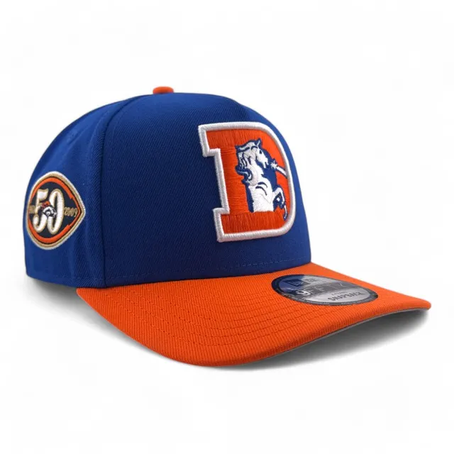 Gorra azul y naranja con logo de caballo en letra "D". Incluye parche conmemorativo "50" y "2009". Diseño deportivo y colorido.