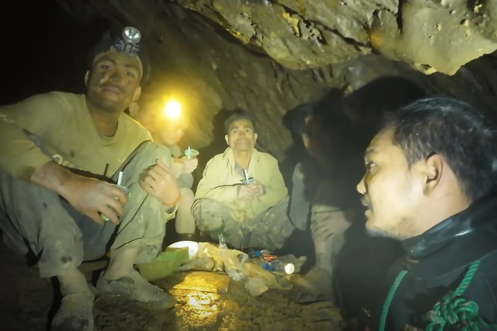 Esta imagen tomada de un video difundido por Benz Norrased Palasing Seascout Diving muestra a rescatistas hablando con pobladores atrapados dentro de una cueva inundada en la provincia de Xaisomboun, el miércoles 27 de mayo de 2026, en Laos. (Benz Norrased Palasing Seascout Diving via AP)