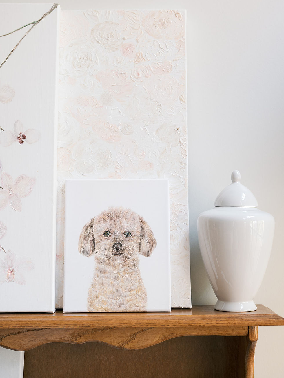 A custom dog painting as a timeless keepsake and styled on a decorated shelf.