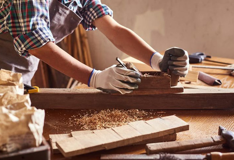 Carpenter working with equipment on wooden table in carpentry shop_ woman works in a carpe