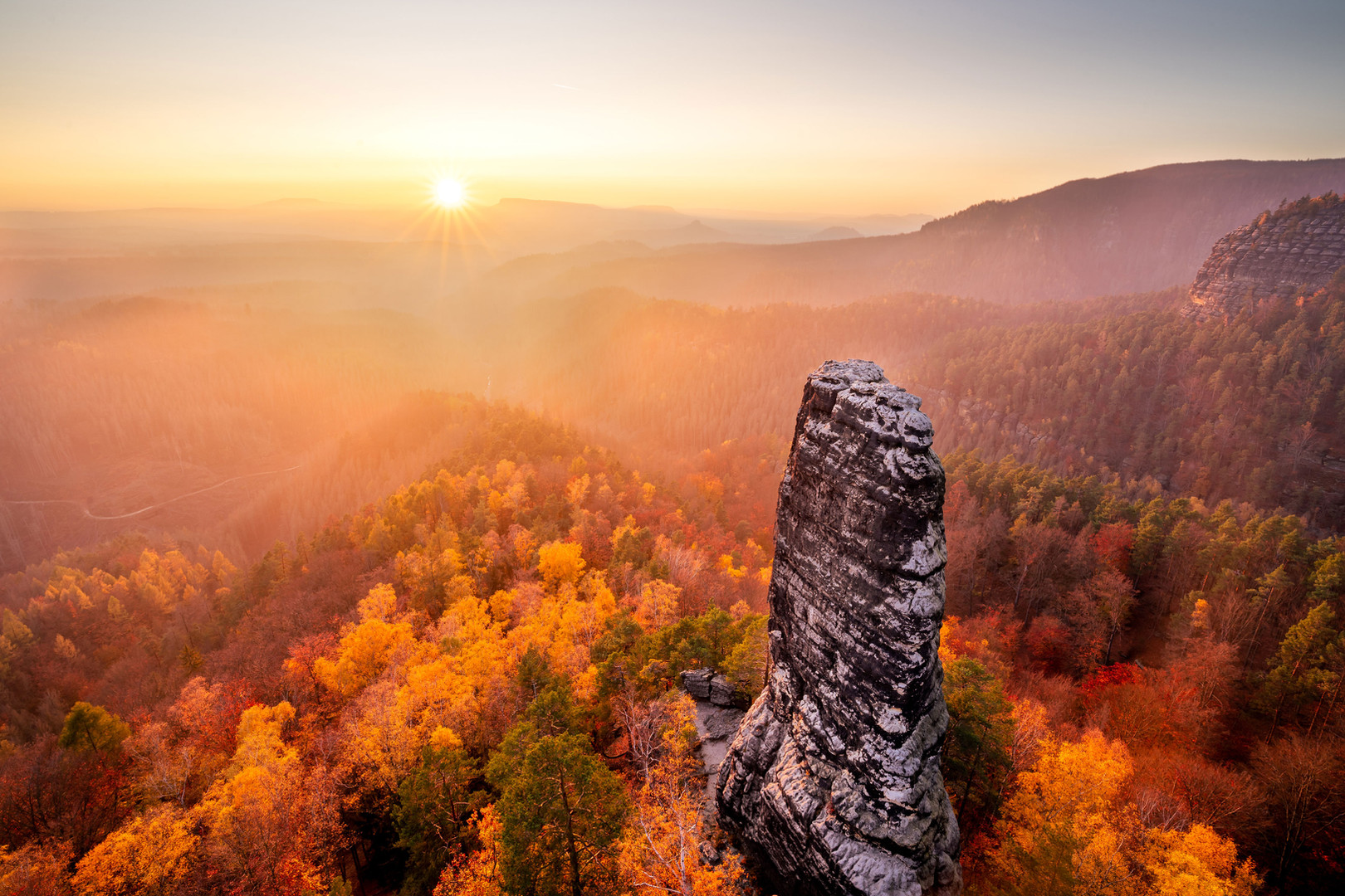 Autumn sunset over Bohemian Switzerland, with beautifully yellow-red colored trees.