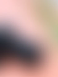 amron 25-200 mm F/2.8-5.6 Di III VXD G2 nasazený na těle Sony, položený na růžovém podkladu vedle krytky a sluneční clony.