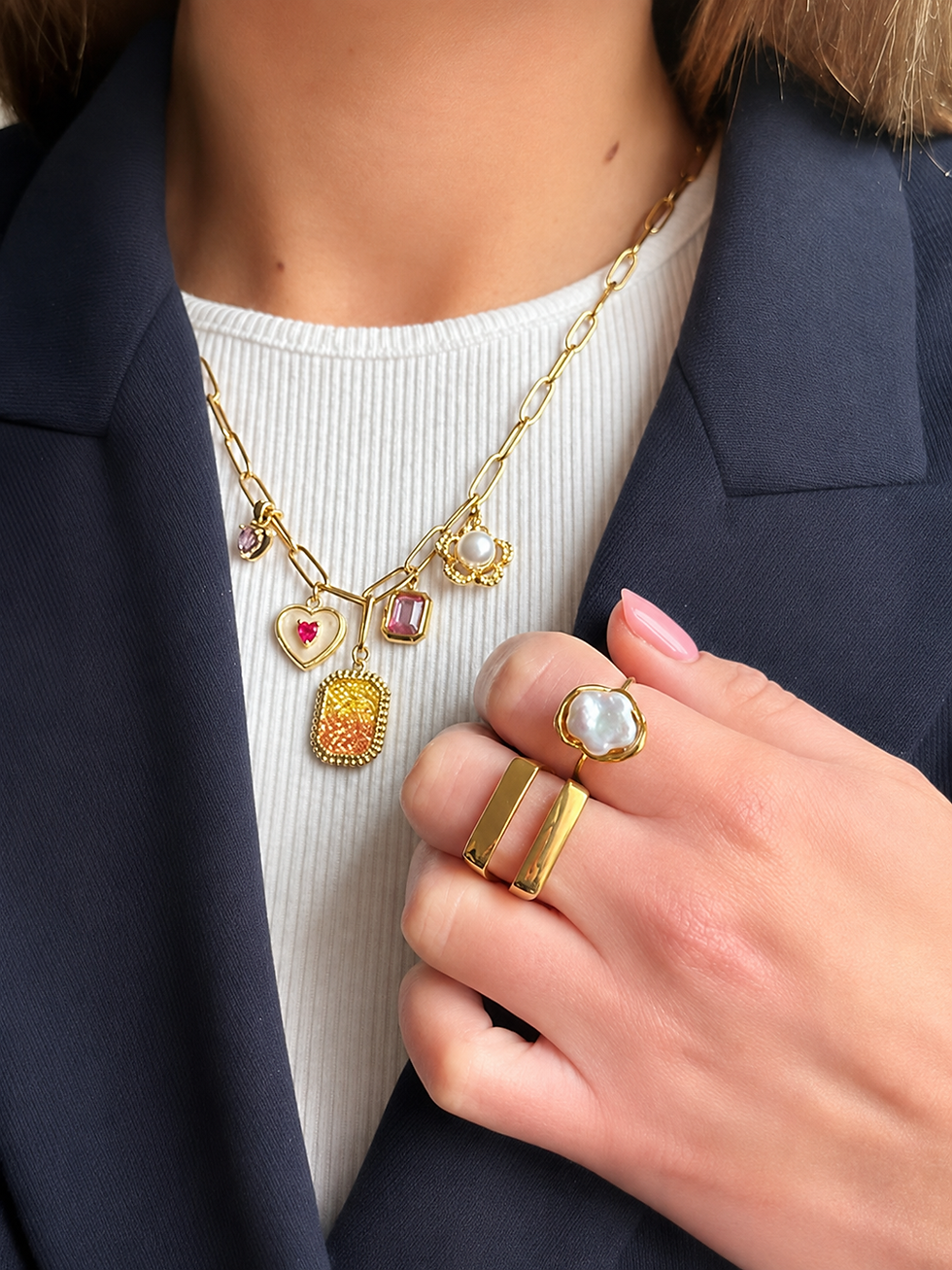 Gros plan d’un cou et d’une main en blazer bleu, portant un collier doré à breloques colorés.