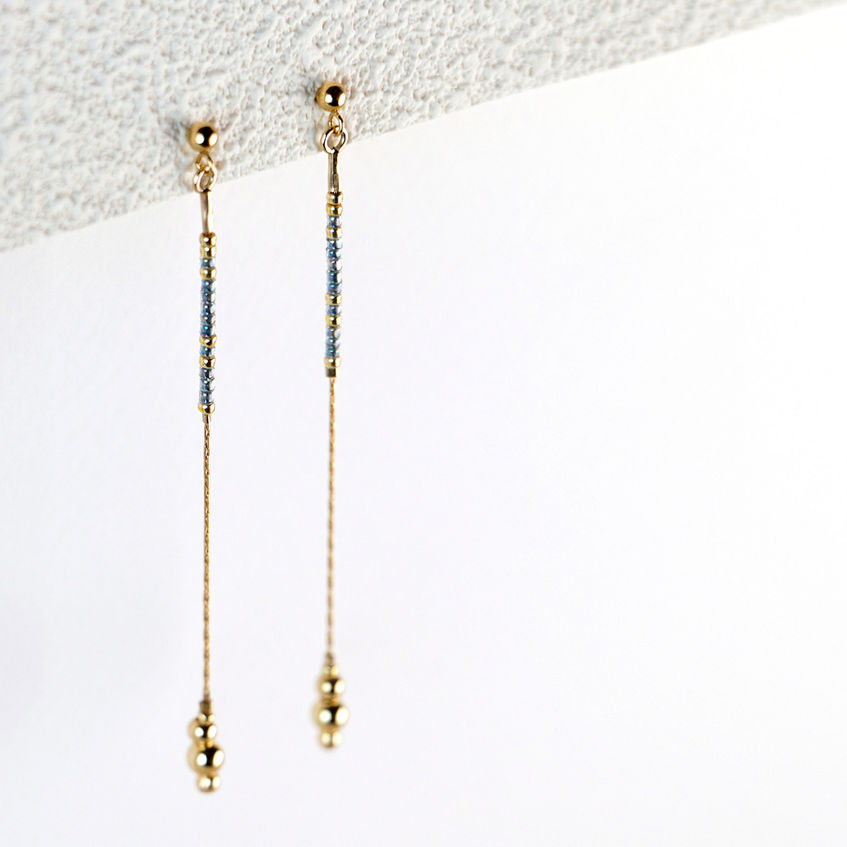 Meya Earrings hanging styled shot on textured paper
