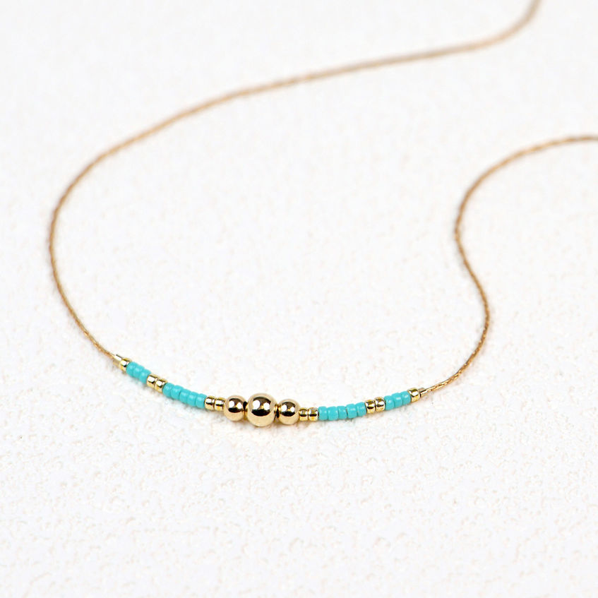 Tirka Necklace flatlay on textured paper