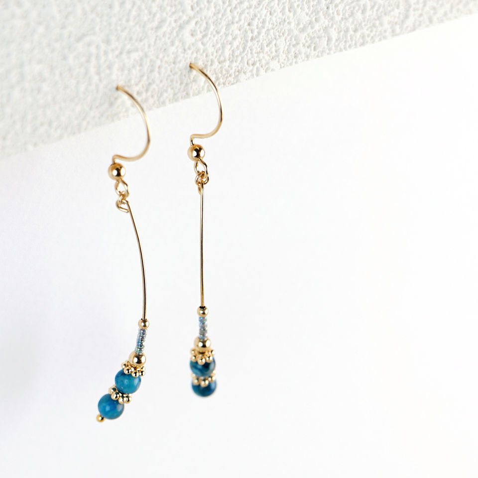 Laana Earrings hanging styled shot on textured paper