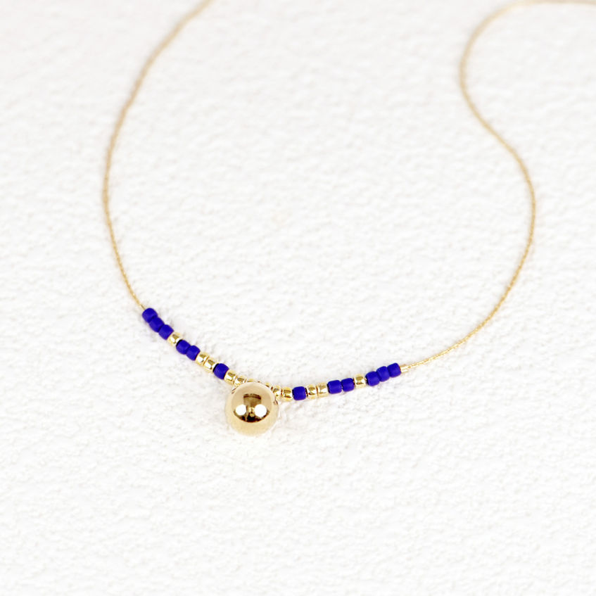 Sara Necklace flatlay on textured paper