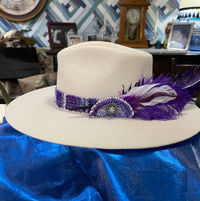 white hat with woven band purple hay band and white and purple feathers.