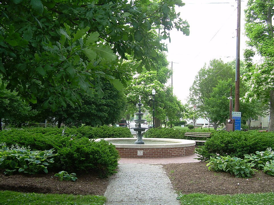 Close-up view of a tree-lined street with Victorian homes and sidewalks in Irvington