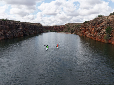 Aerial view of a paddler winding through a canyon in Western Australia