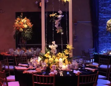 A beautifully arranged table adorned with vibrant yellow and white flowers at The Space at Westbury.