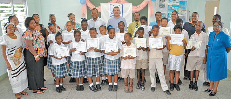 Joel Primus, back row, fifth from left, community sustainability and stakeholder relations adviser, bpTT; and Christopher Bonterre, back row, centre, director, Arrow Foundation, share a proud moment with the top performing students and teachers of Carenage Boys’ and Carenage Girls’ Primary Schools at the graduation.