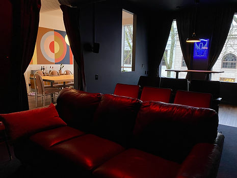 A couch and theater seats in a dimly lit screening room.