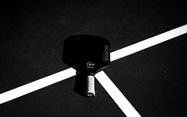 A close up of a tennis racket on a court