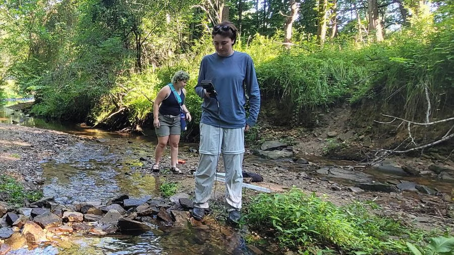 Norah Shires uses a DO meter at Galloway Creek to measure temperature and oxygen levels.
