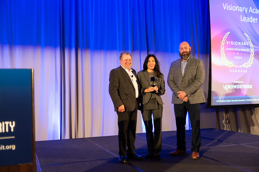 Holly Yuan, center, program director of B.S. cybersecurity and B.S. computer networking and infrastructure engineering at UW-Stout, receives her Visionary Academic Leadership Award at the 14th annual Cyber Security Summit, in Minneapolis. Photo by cybersecuritysummit.org.