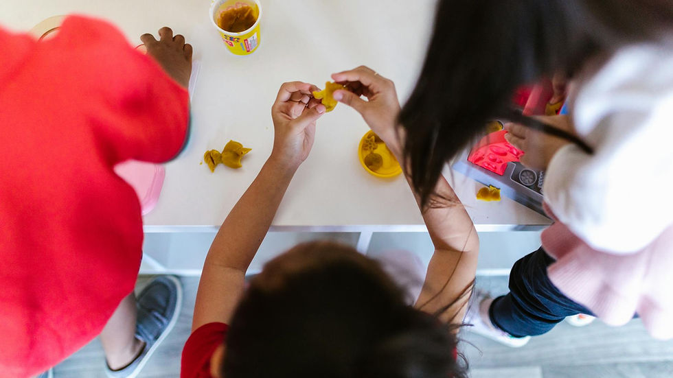 Overhead view of kids playing and learning with clay at a table.