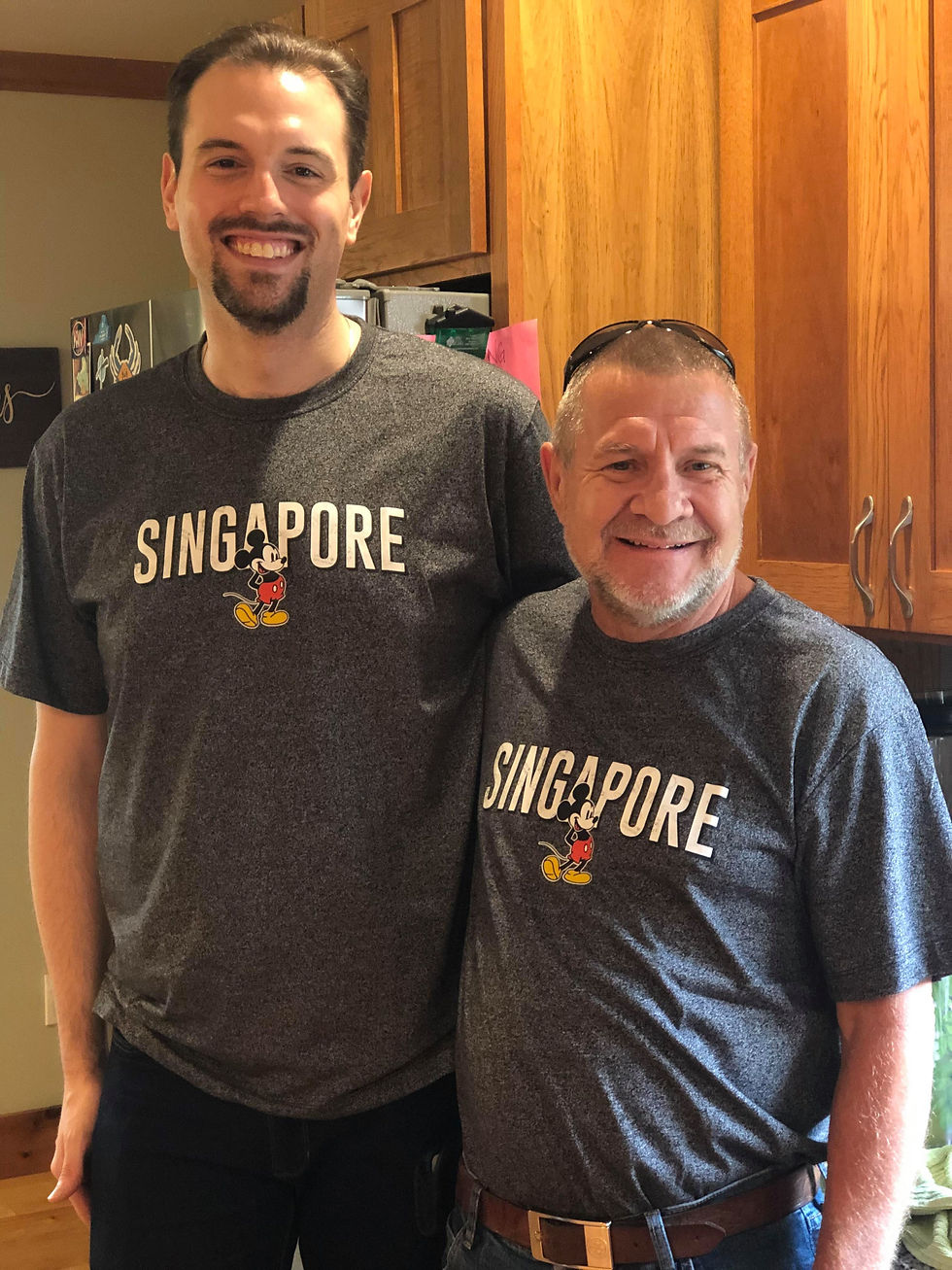 Tall and short men smiling wearing grey singapore shirts